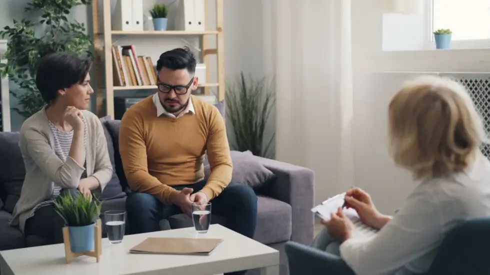 Couple sitting with a therapist during a couples therapy session